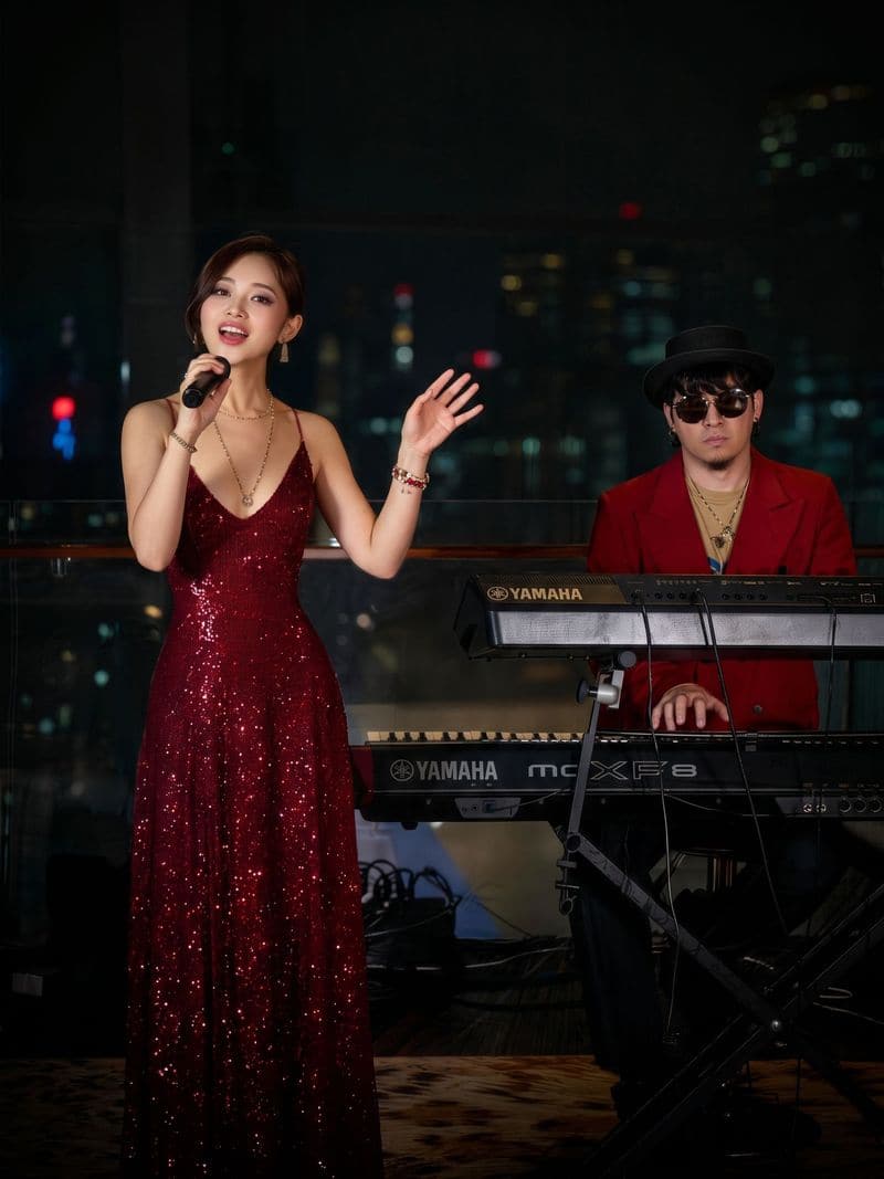 Jaya Lee in a red sequin dress with a keyboardist behind her